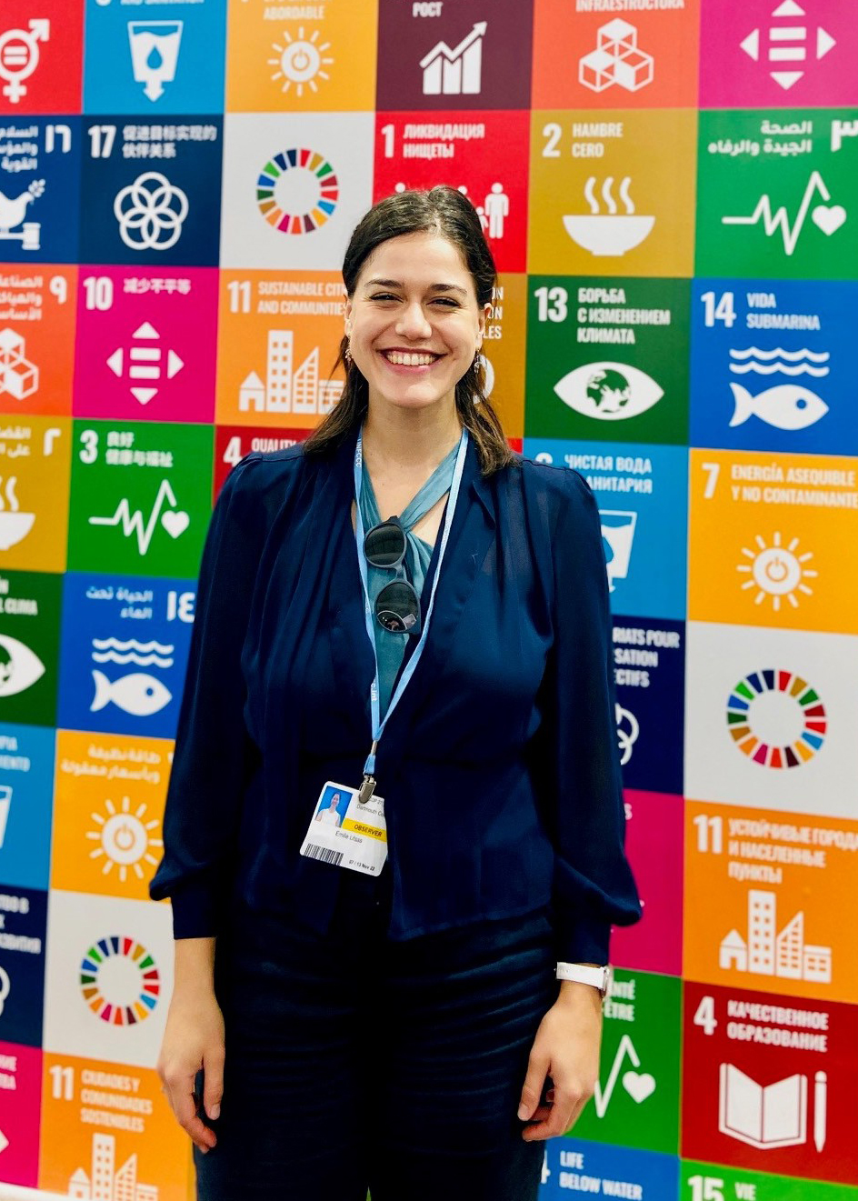 Emilie Litsas standing in front of a wall with colorful blocks and symbols